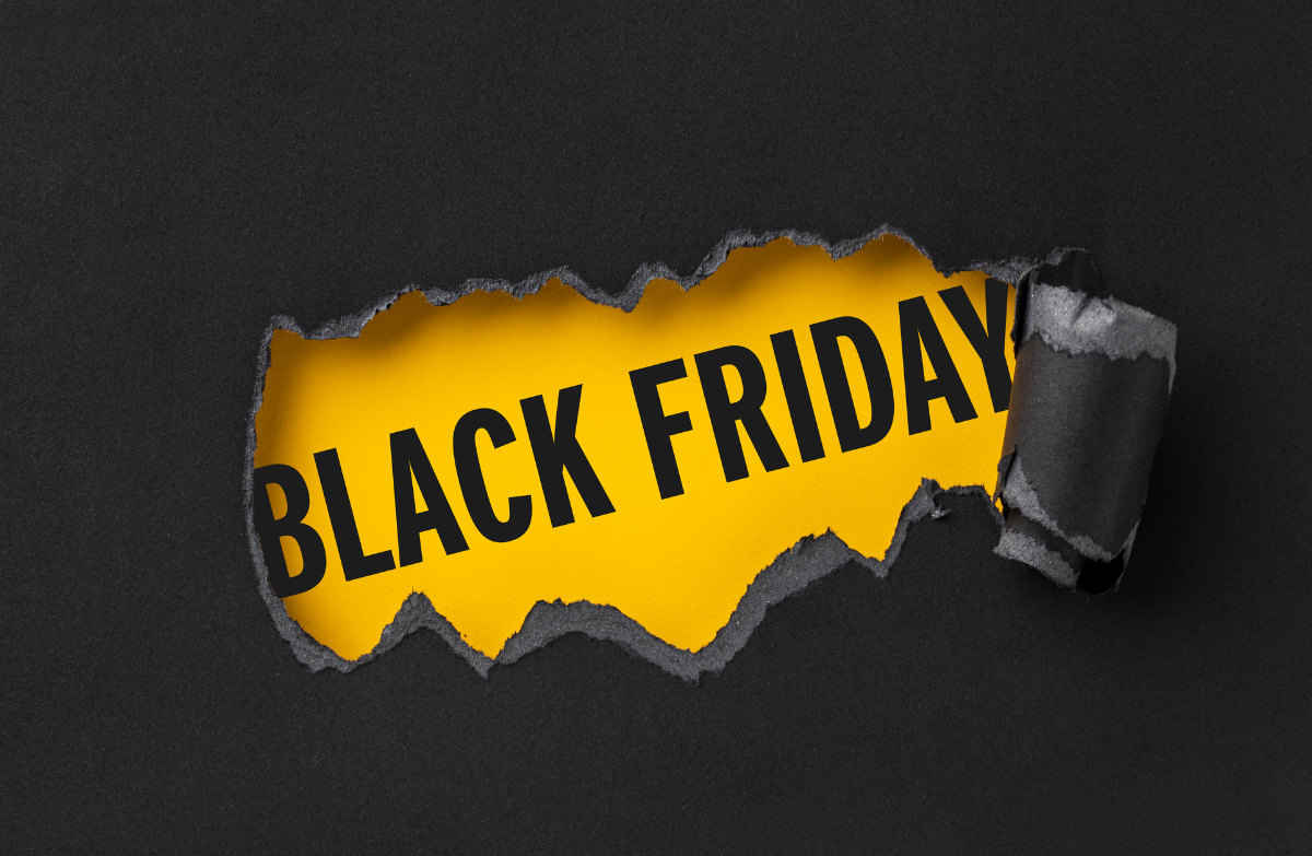 Black Friday text revealed through torn black paper showing a bright yellow background