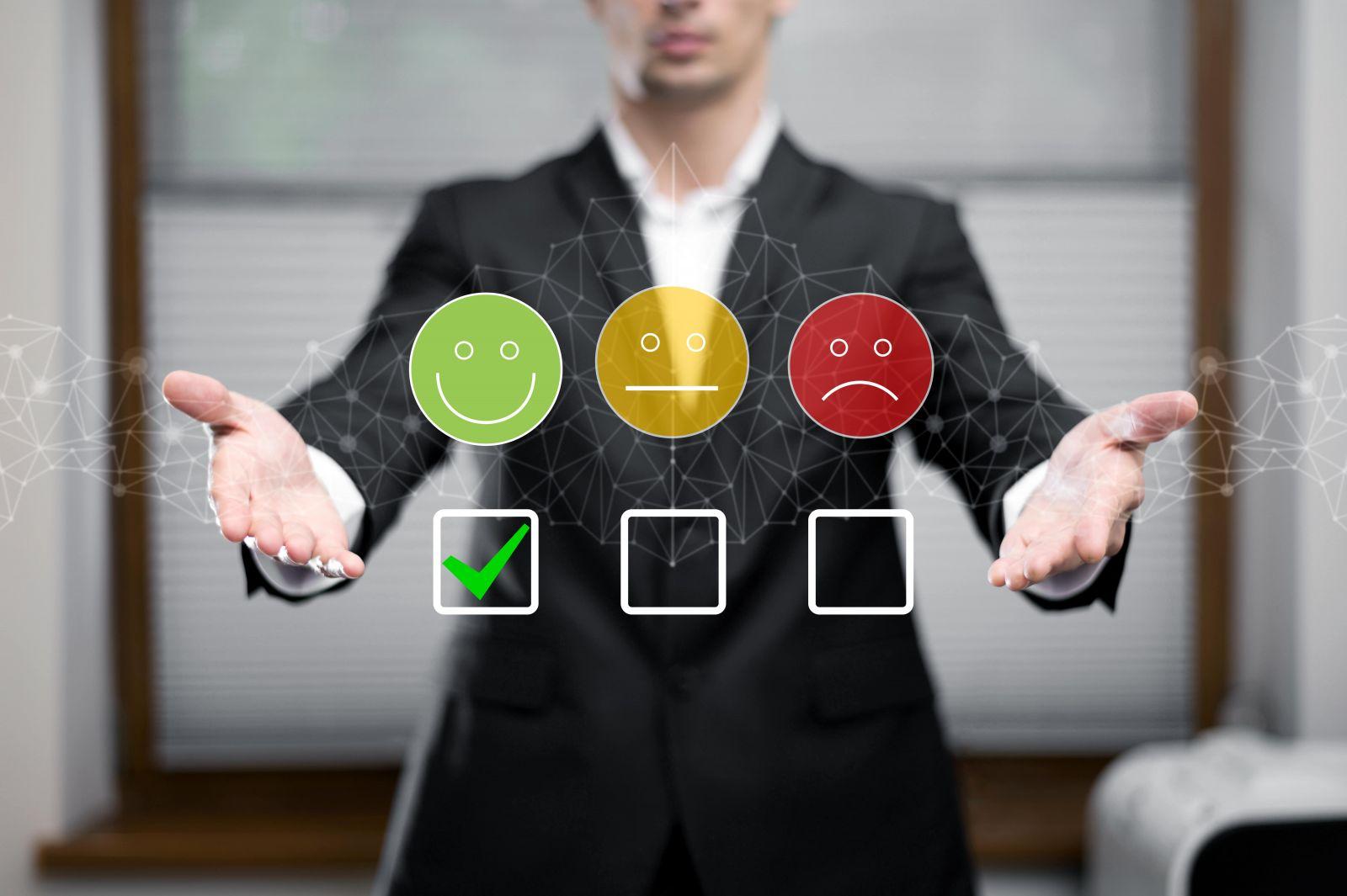 Man in suit presenting three emoji feedback options with green smiling face checked