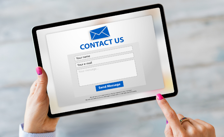 Person using a tablet displaying a contact us enquiry form with fields for name, email and message and a send message button