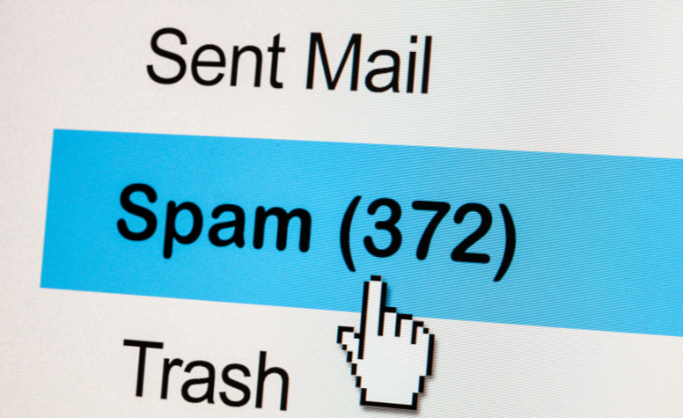 Computer screen showing an email interface with the Spam folder highlighted and a cursor pointing to it