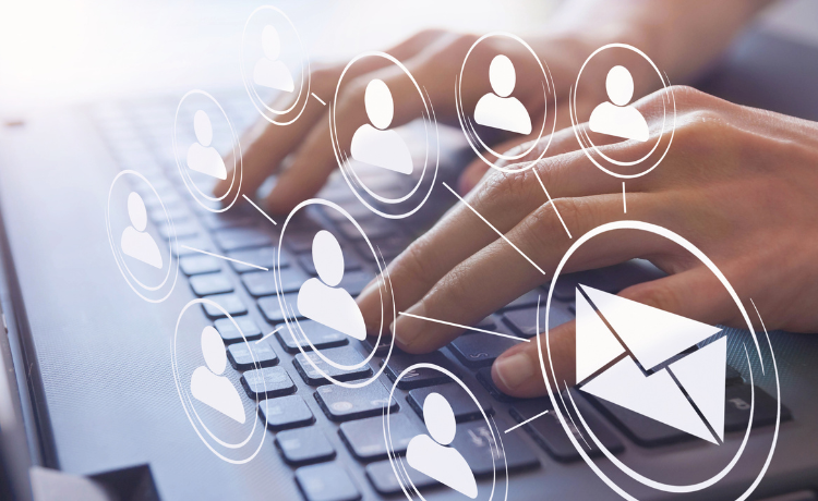 Hands typing on a laptop keyboard with digital icons of user profiles and an envelope symbolising email communication and inbound enquiries