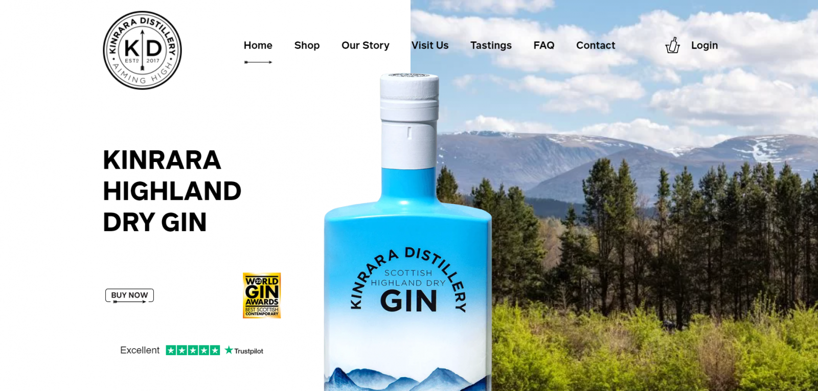 Blue and white bottle of Kinrara Distillery Scottish Highland Dry Gin with mountainous landscape and forest behind it under a blue sky with clouds