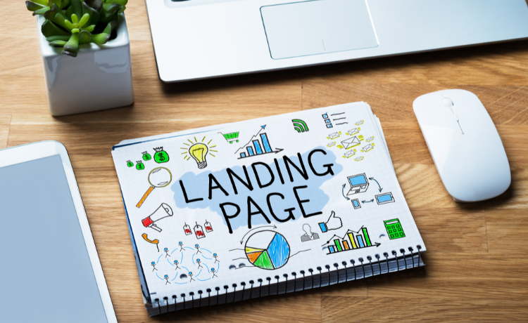 Notebook with 'Landing Page' title and business strategy doodles beside laptop, mouse and tablet on wooden desk