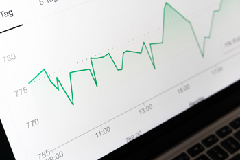 Graph line chart displaying fluctuating data trends on a laptop screen with time and numeric values