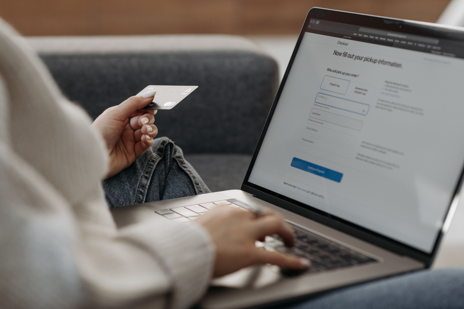 Person holding credit card and entering information on laptop checkout screen to fill out pickup details