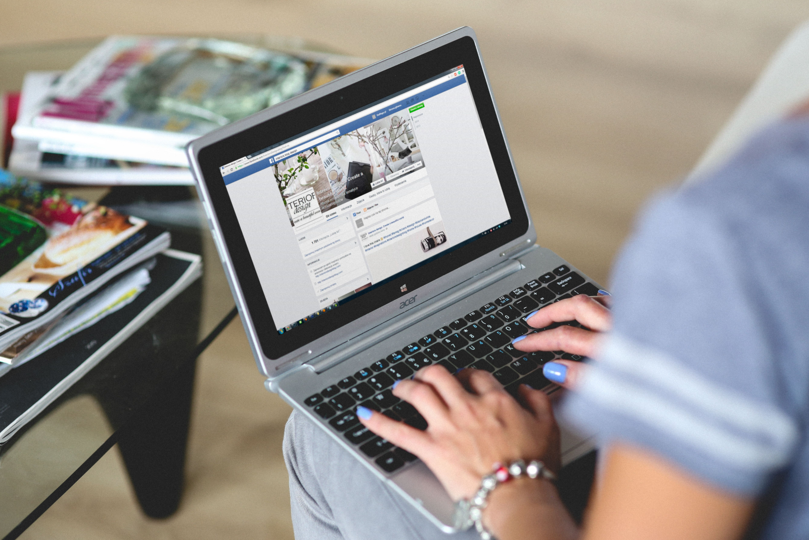 Person typing on a laptop showing a Facebook page for an interior design business