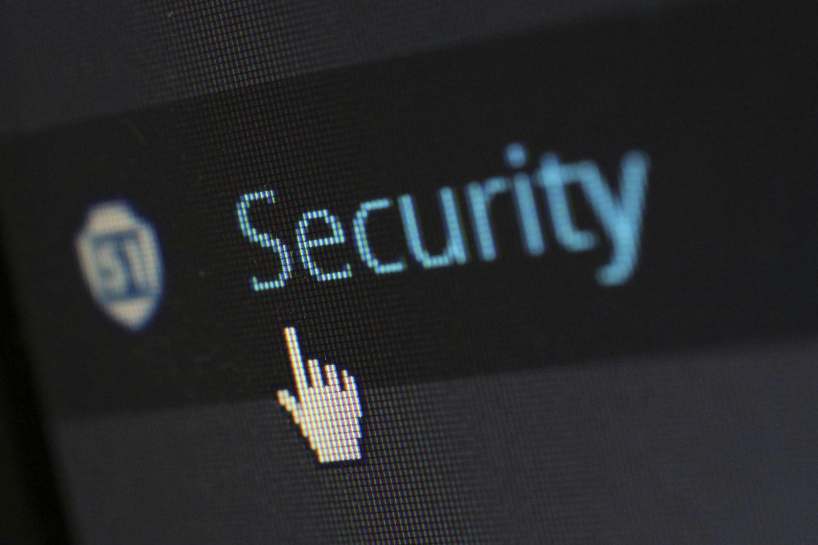 Close-up of a computer screen showing the word 'Security' and a pixelated hand cursor pointing at it