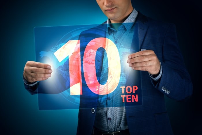 Man in a blue suit holding a translucent digital screen showing the number 10 and the words Top Ten
