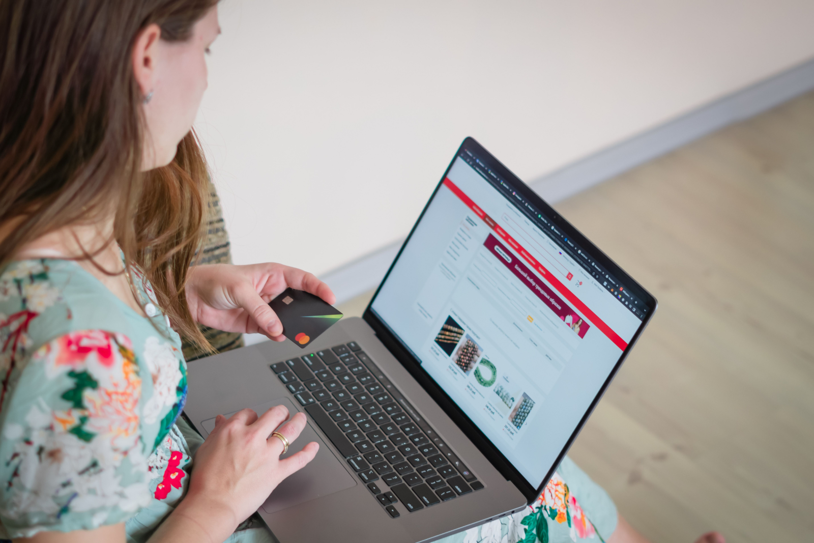 Woman holding a credit card and using a laptop to shop online on an e-commerce website