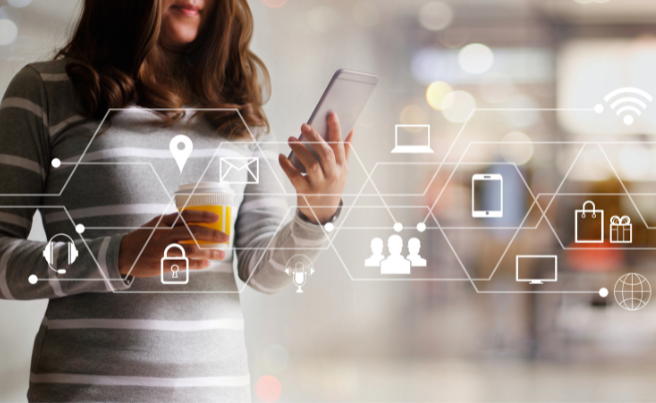 Woman holding a smartphone and coffee cup with digital marketing and technology icons overlay