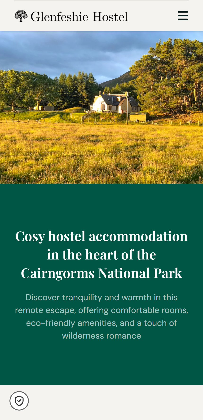 Glenfeshie Hostel building surrounded by trees and grassy fields under a cloudy sky, showcasing cosy accommodation in the Cairngorms National Park
