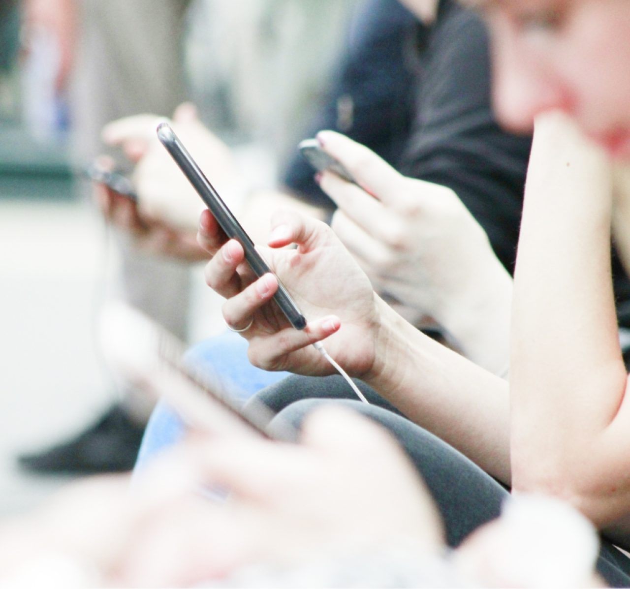 Hands holding and using smartphones in a close-up view illustrating digital connectivity and communication