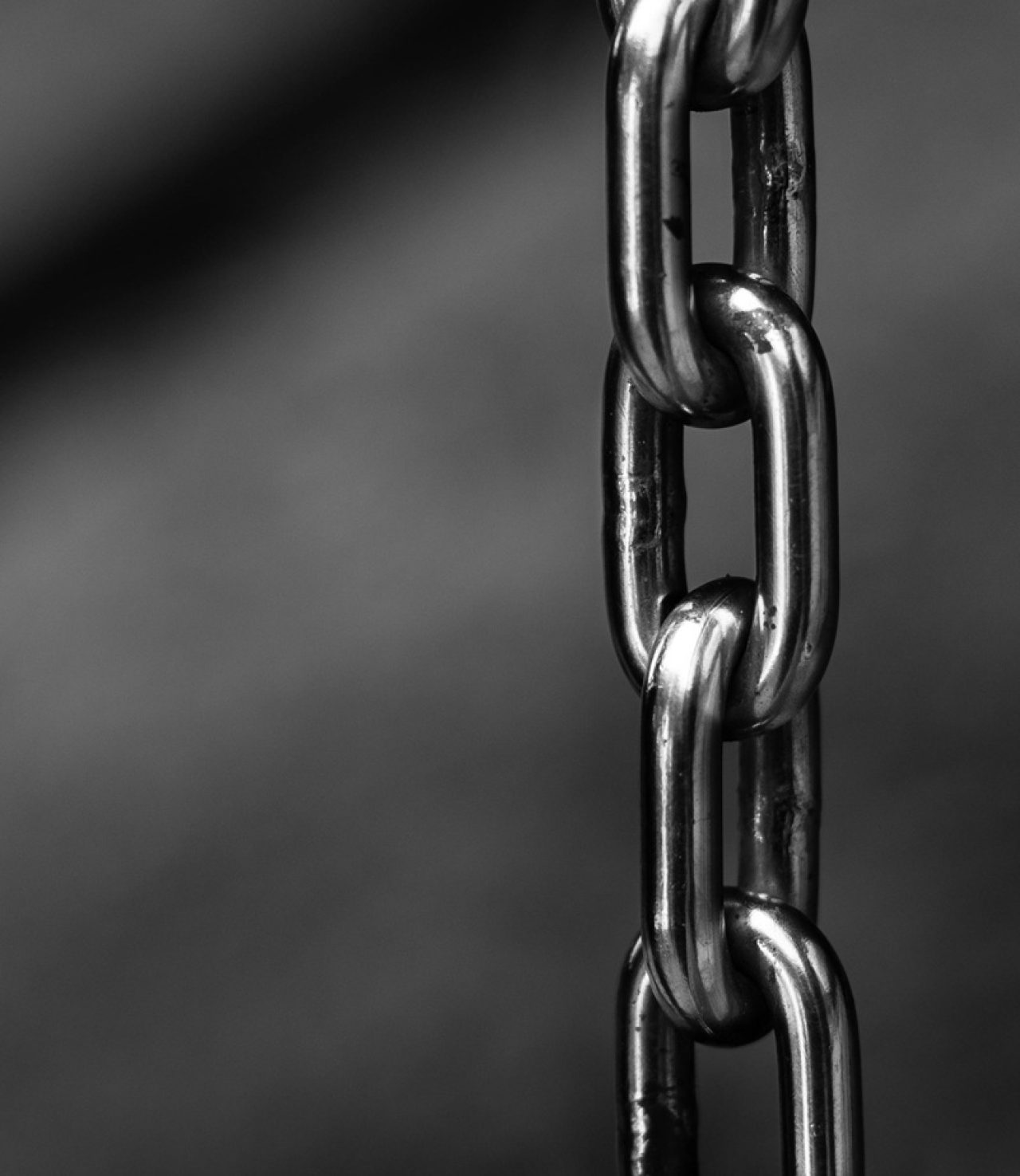 Close-up black-and-white photo of interconnected metal chain links.