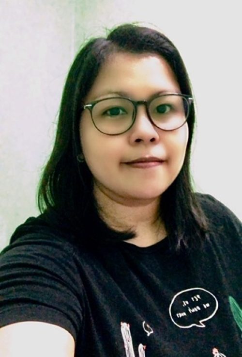 Portrait of a woman with glasses wearing a black t-shirt, facing forward with a neutral expression