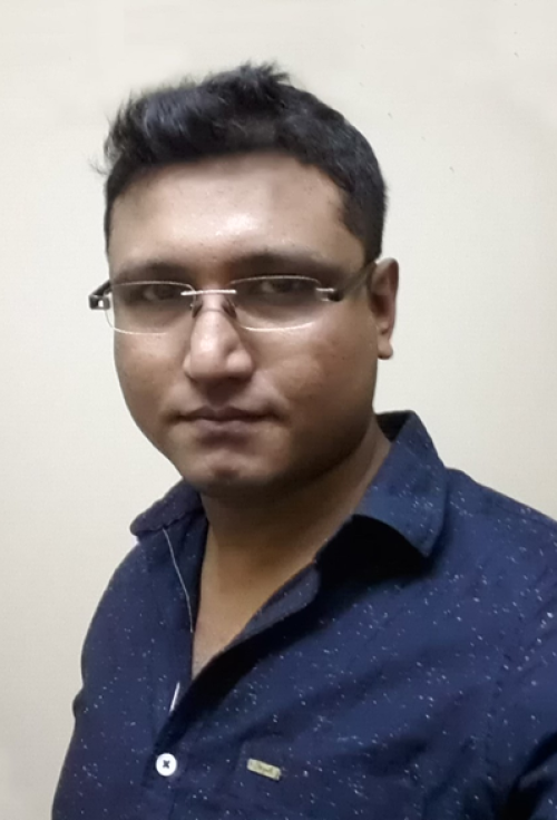 Portrait of Kuladeep Das wearing glasses and a dark shirt
