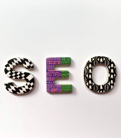 Decorative letters S, E and O with black, white, purple and green patterns on a white background