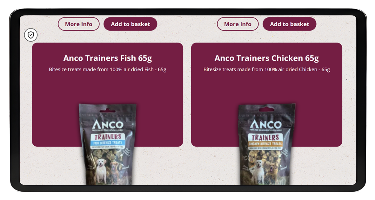 Tablet screen showing the Anco Dog Treats eCommerce website with product listings for Trainers Fish 65g and Trainers Chicken 65g bitesize treats