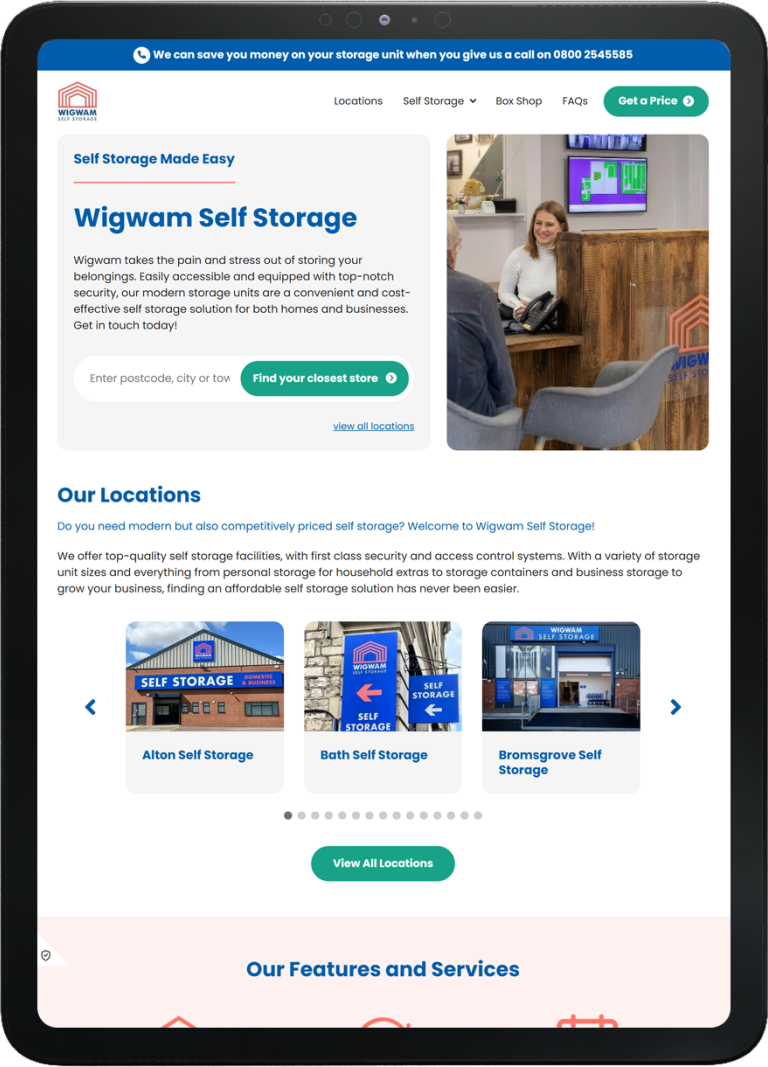 Tablet displaying Wigwam Self Storage website with a customer speaking to a receptionist at a wooden counter